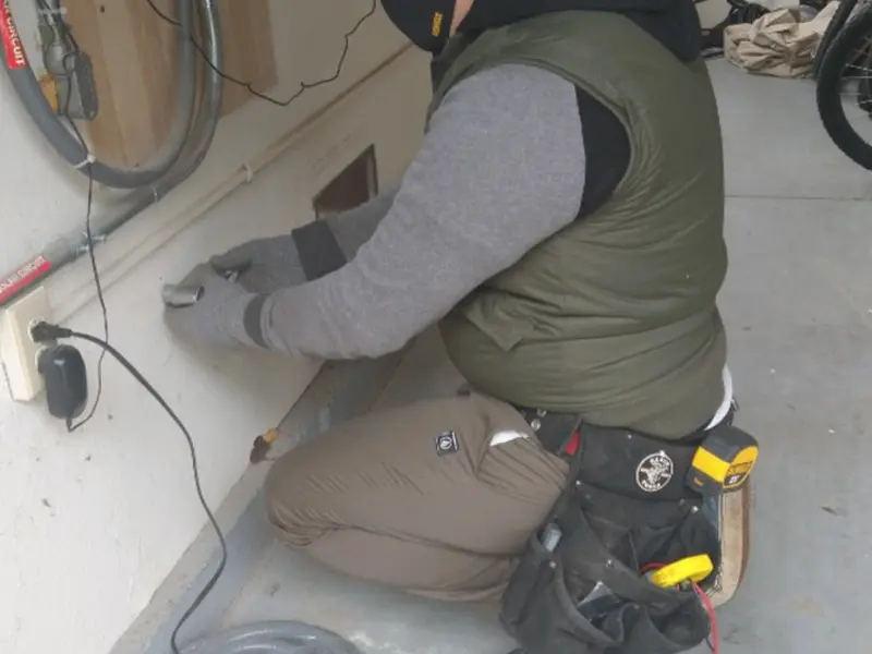 Electrician performing outlet wiring in a East Windsor garage